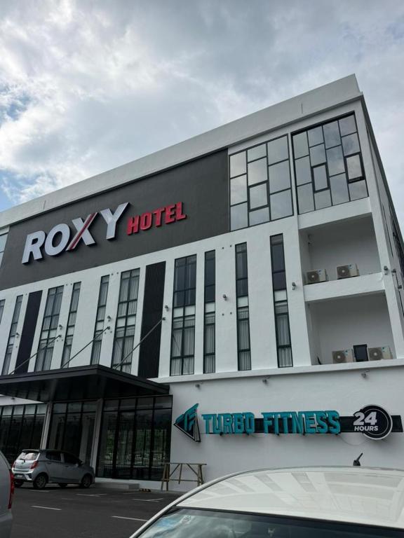 a building with a rocky hotel with a car parked in front at Roxy Hotel & Apartment Lawas in Lawas