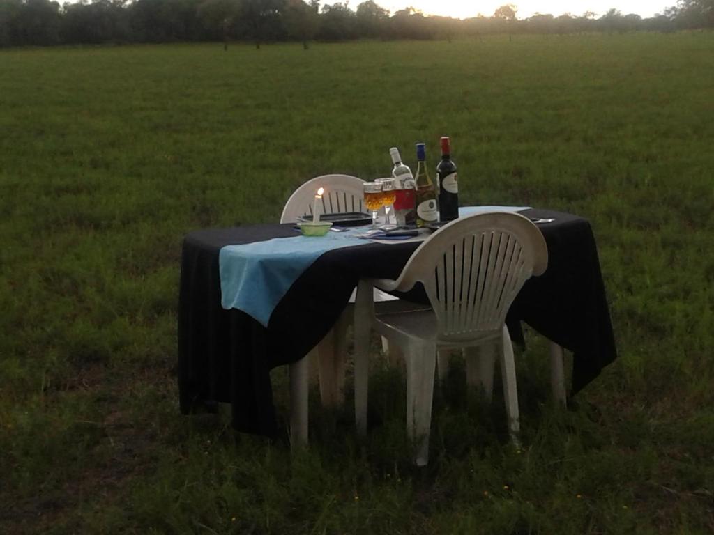 a table with two chairs and a bottle of wine at Paradise Nature Tented Camp in Groutfontein