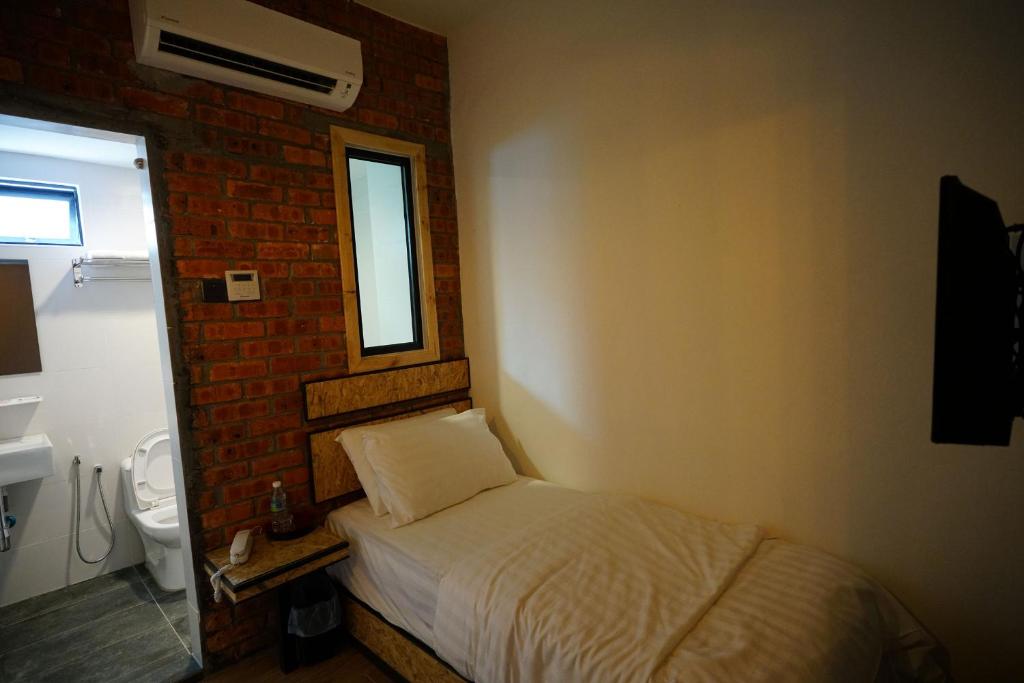 Postel nebo postele na pokoji v ubytování Brick Box Hotel @ Oldtown Ipoh