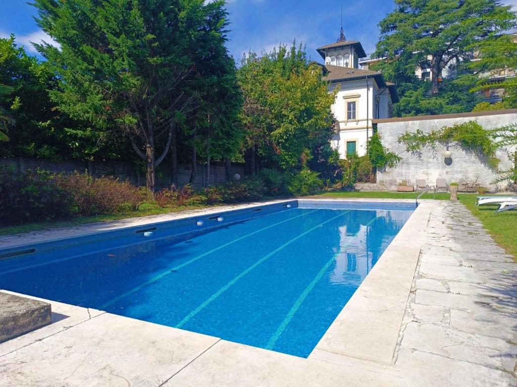 a swimming pool in front of a house at Emy charming apartment with pool in Verbania