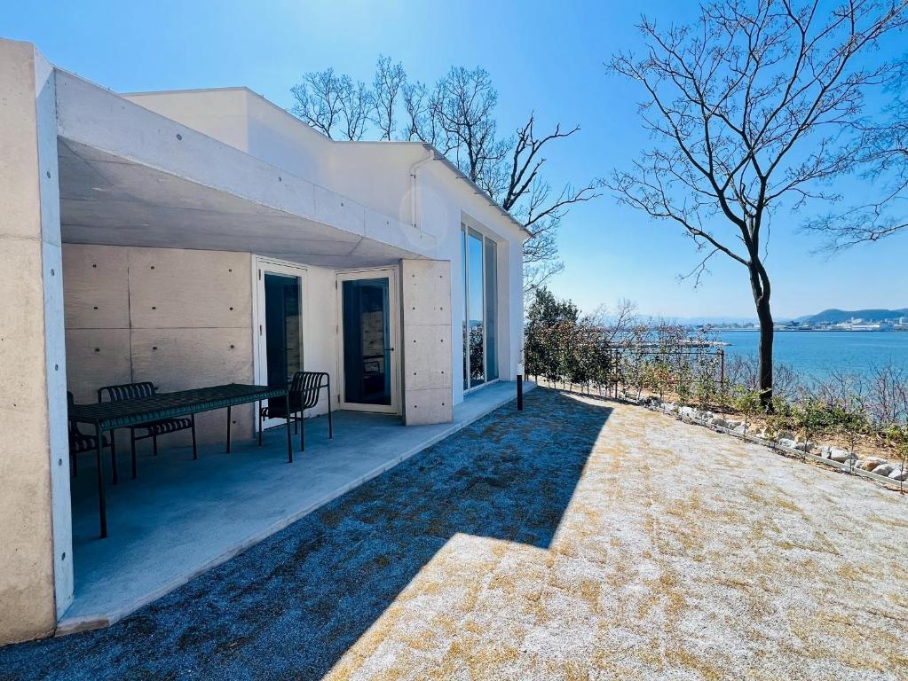 a house with a patio with a table and a tree at Auberge de Oishi in Takamatsu