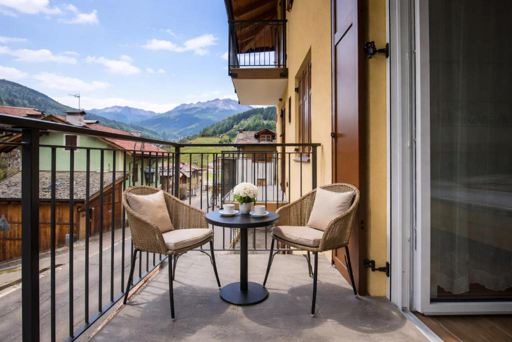 a balcony with two chairs and a table with a view at MOUNTAIN HOME Fiemme - Nuovo, Balconi e Garage in Castello di Fiemme