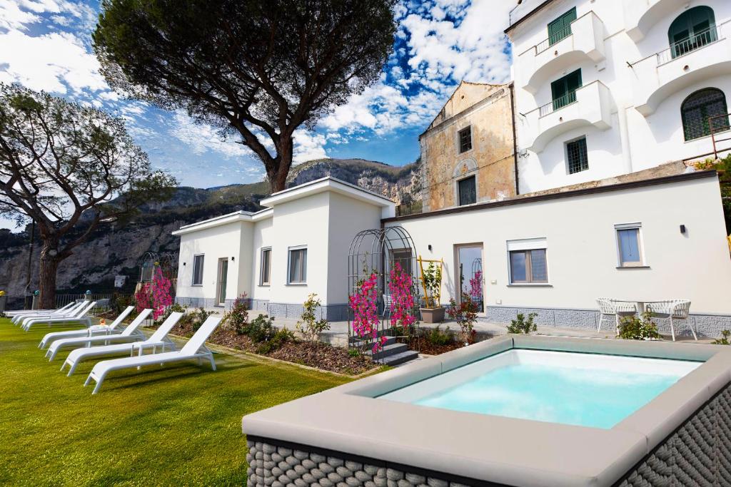 a pool in front of a building with lounge chairs at Borgo Sant'Anna in Amalfi