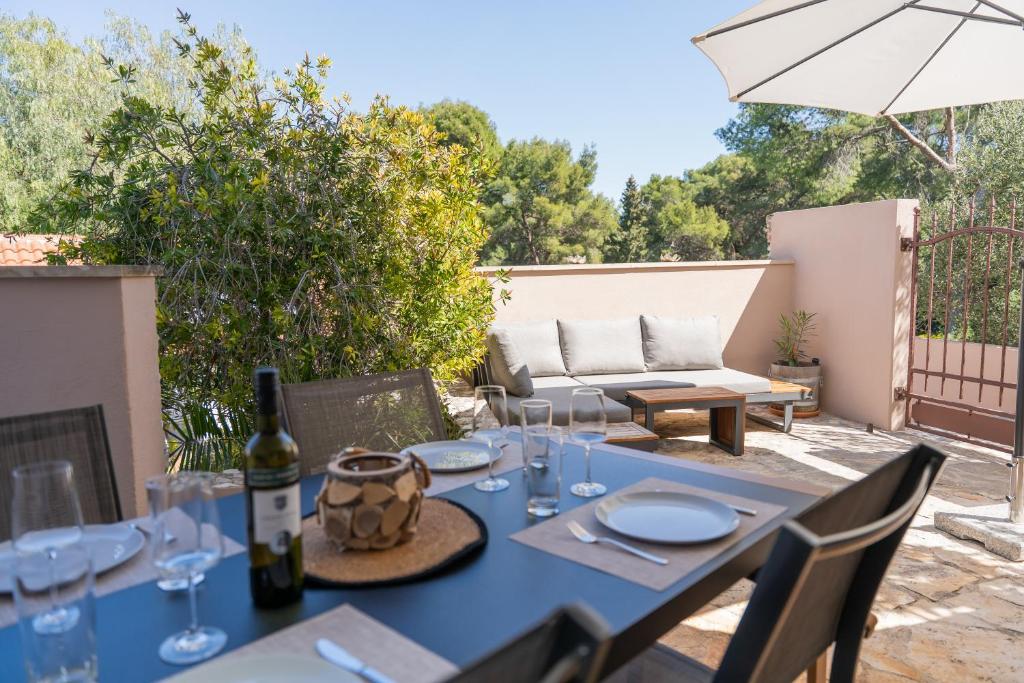 a blue table with glasses and a bottle of wine at Laurentina - Modern Apartment with Large Terrace near Beach-quiet and comfortable in Sutivan