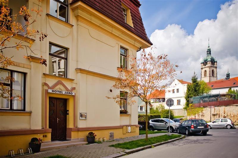 ein Gebäude mit auf einem Parkplatz abgestellten Autos in der Unterkunft Hotel Jaro in Mělník