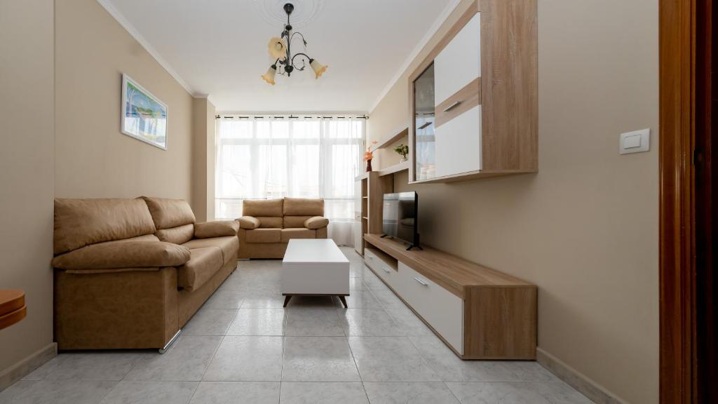 a living room with a couch and a table at Langosteira Beach, spacious apartment in Fisterra