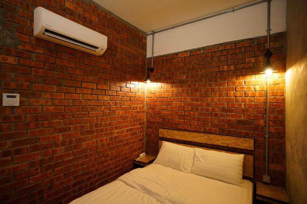 Postel nebo postele na pokoji v ubytování Brick Box Hotel @ Oldtown Ipoh