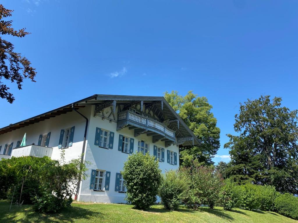 a white building with a balcony on top of it at Ferienwohnung Schwark Haus Elisabeth in Aschau im Chiemgau