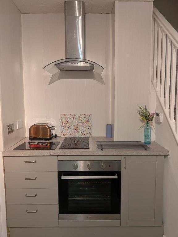 a kitchen with a stove and a stove top oven at Sandham Hall Cottage in Sandown