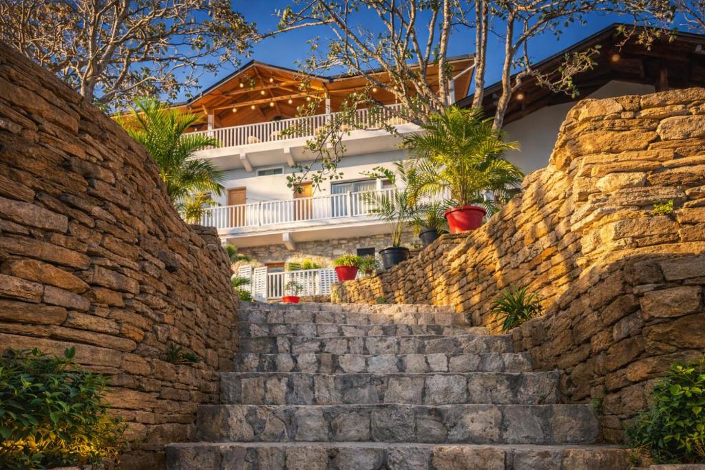 a stone wall with stairs in front of a house at Omaya Vista in Mukteshwar