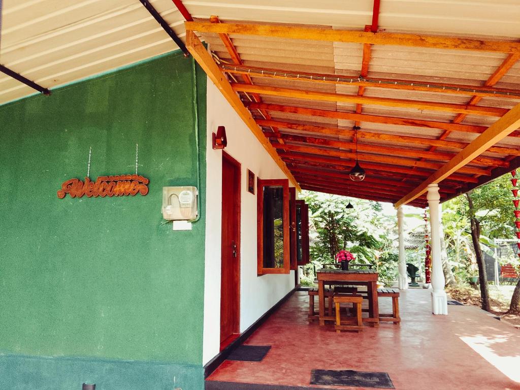 a green and white building with a wooden roof at Canal Resort Udawalawa in Ratkarawwa