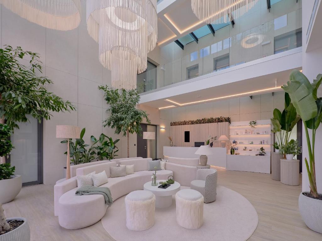 a lobby with white furniture and potted plants at Evergreen Health Longevity Residence in Kehidakustány