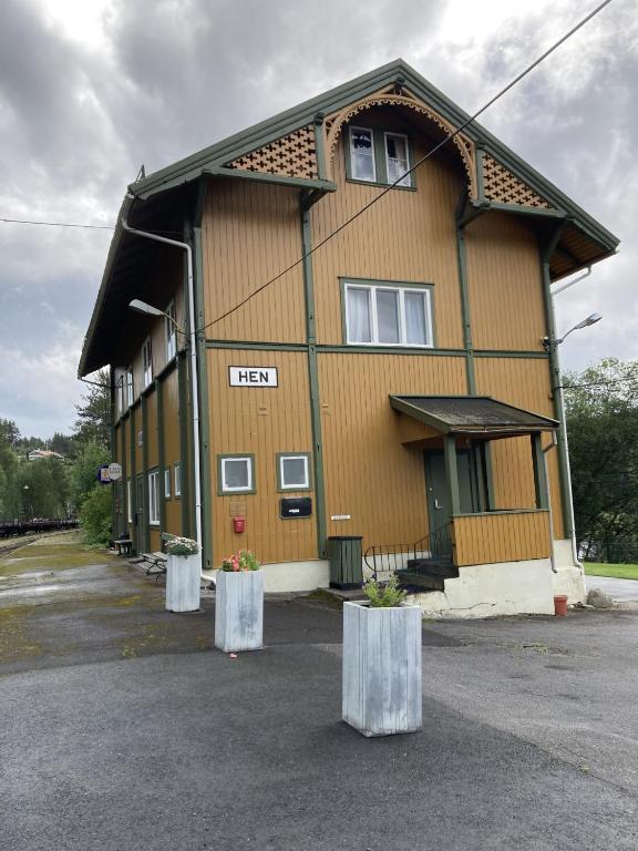 a large building with two pillars in front of it at Hen Stasjon Banevokterboligen in Hen