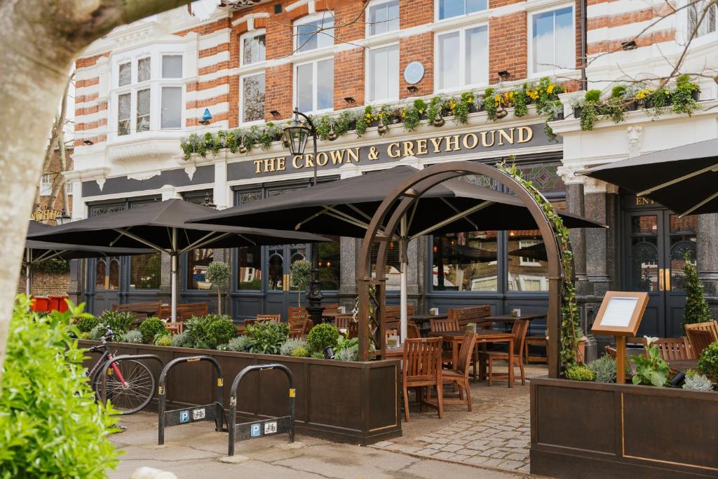 a restaurant with tables and chairs in front of a building at The Crown & Greyhound by Innkeeper's Collection in London