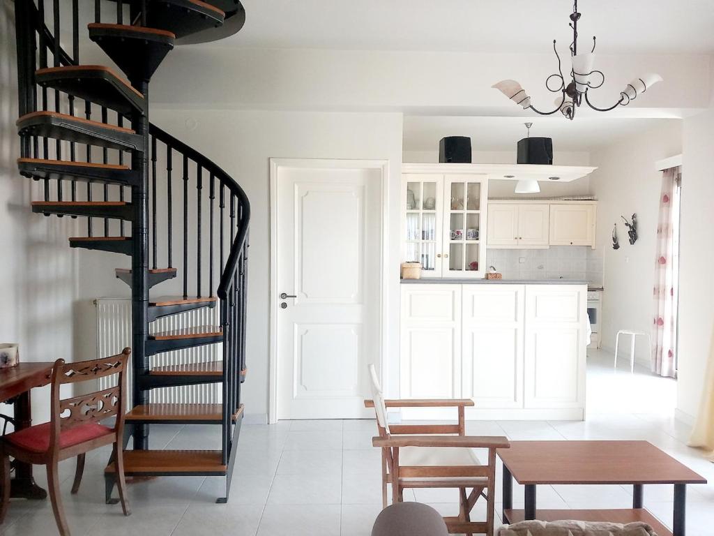 a living room with a spiral staircase and a table at Family Booklovers space in Aigio
