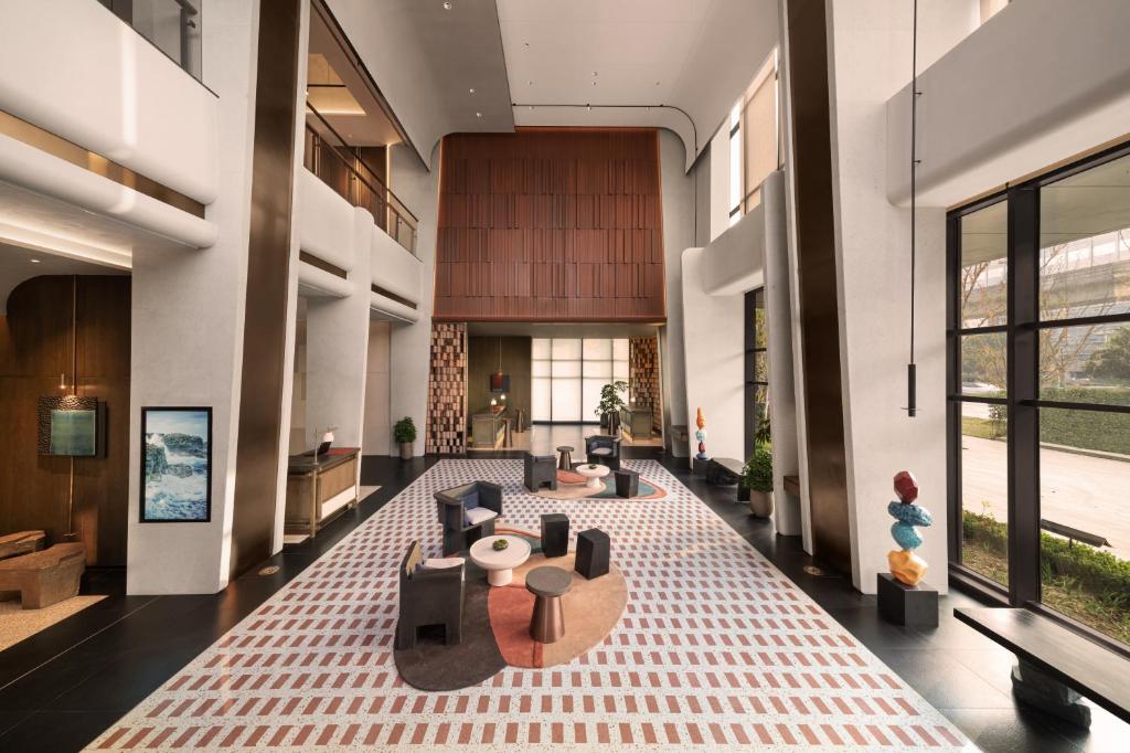 a lobby with couches and tables in a building at 苏州云启一方酒店-凯悦尚选 in Suzhou