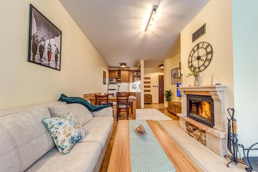 a living room with a couch and a fireplace at Ember Suite 1BR - Mountain Lake Complex By Flat Mаnager in Smolyan