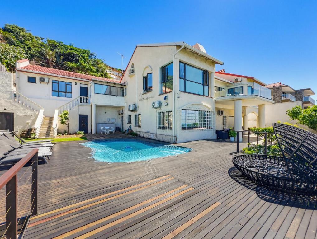 a large house with a deck and a swimming pool at The Coastal Crown in Ballito