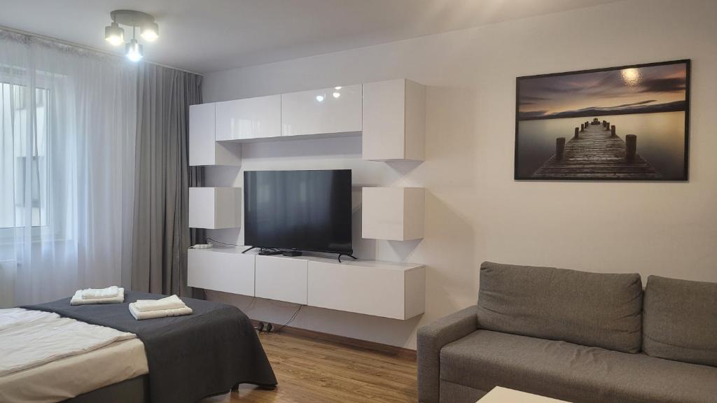 a living room with a television and a couch at Przestronny Apartament typu Studio, GARAŻ W CENIE in Wrocław