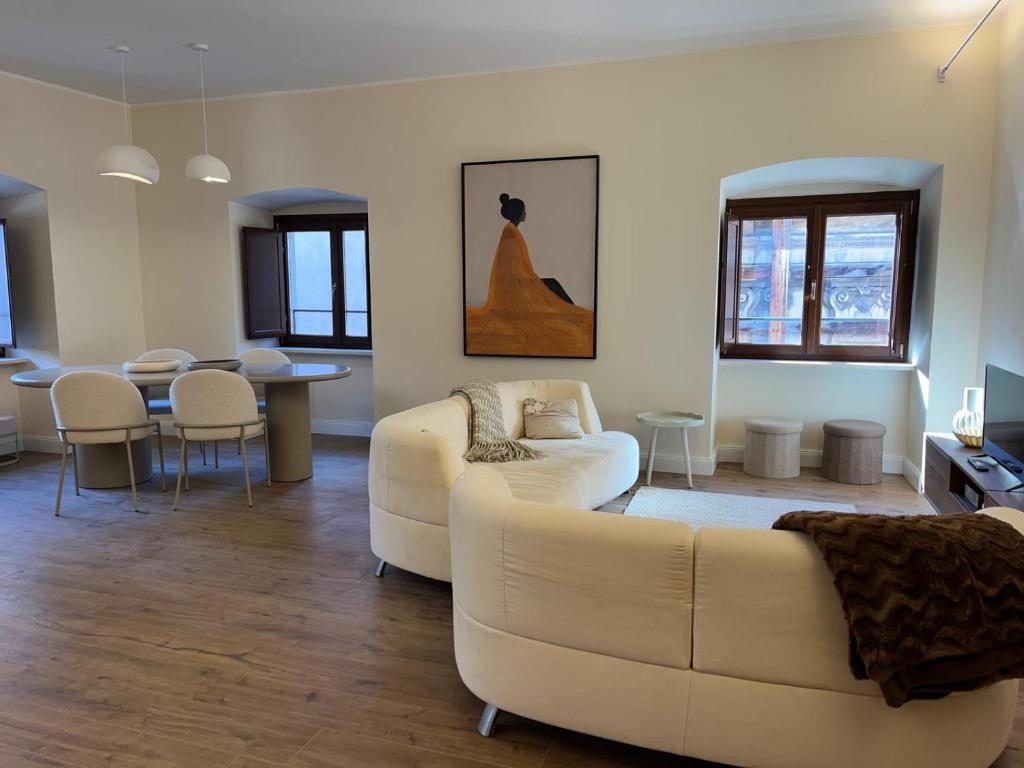 a living room with a white couch and a table at Cavour Apartment in LʼAquila
