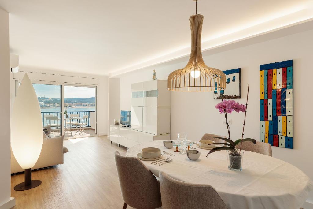a dining room with a white table and chairs at La Escala- Costa Brava pool duplex apartment in L'Escala