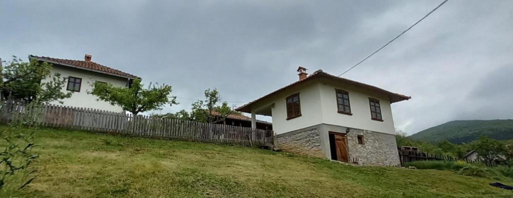a white house on a hill with a fence at Ramaća House in Ramaća