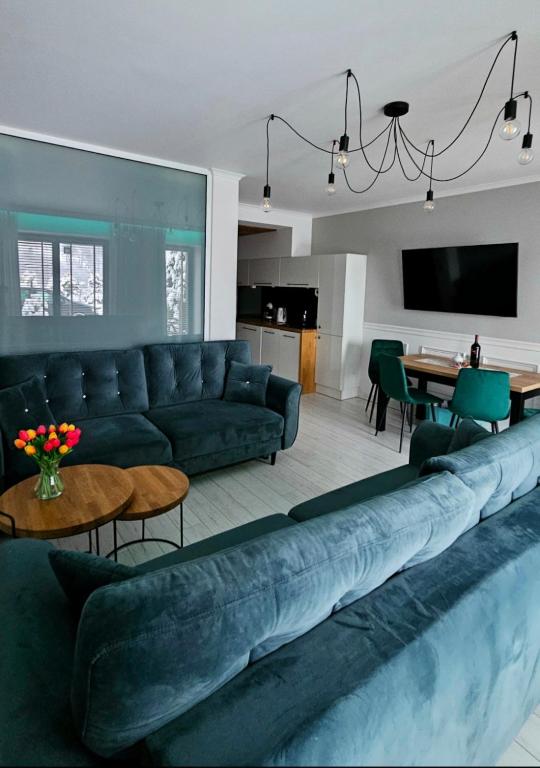 a living room with a blue couch and a table at Apartament Sun Hill in Wisła