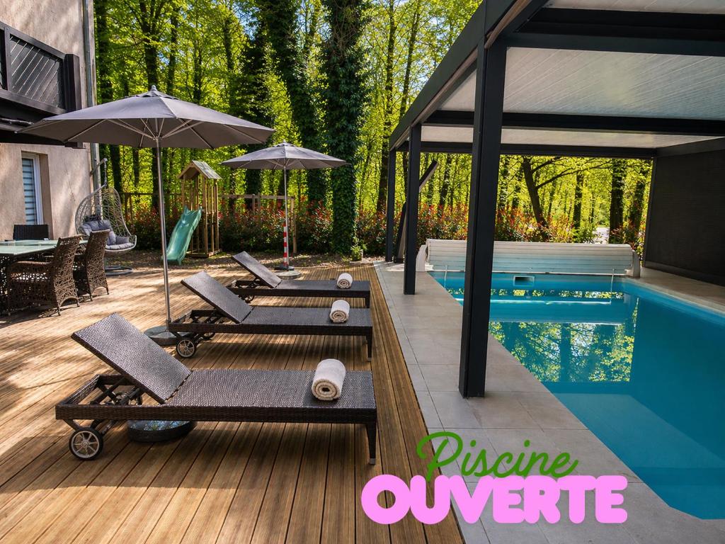 a swimming pool with lounge chairs and an umbrella at Enzo Hôtels Diane - Logis Amnéville in Amnéville