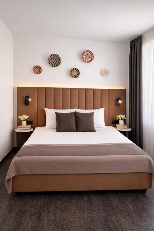 a bedroom with a large bed and two tables at Bayer's City Hotel in Munich