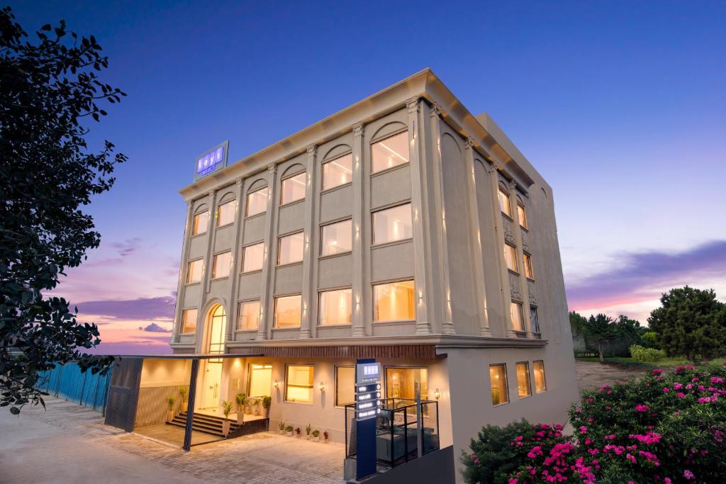 a building with a lit up facade at dusk at Keys Select by Lemon Tree Hotels, Amritsar in Amritsar