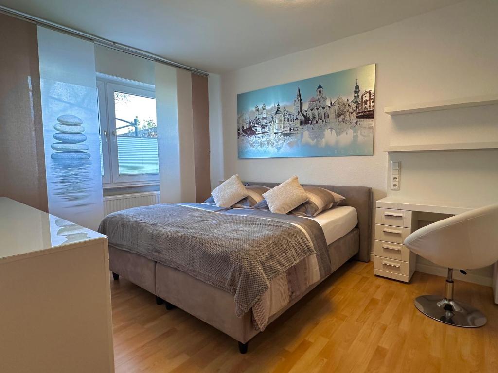 a bedroom with a bed and a desk and a window at Wasserburg 1 I Familienfreundlich - Ruhig & Erdgeschoss I Parkplatz inkl in Paderborn