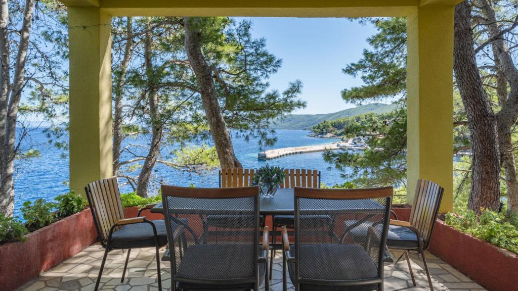 a porch with a table and chairs overlooking a lake at House Katarina by Villas Guide in Blato