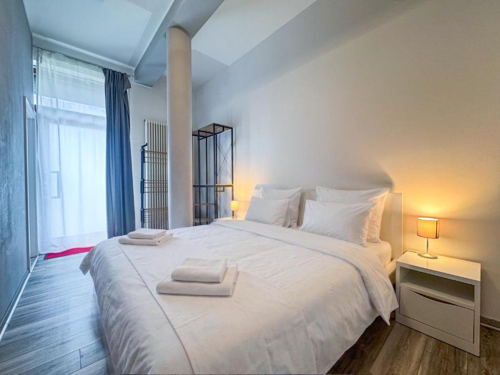 a bedroom with a large white bed with towels on it at City-Apartment Timeless in Berlin