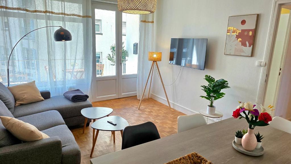 a living room with a couch and a table at Le Repaire - Hyper centre, 3 ch, balcon et parking in Le Mans