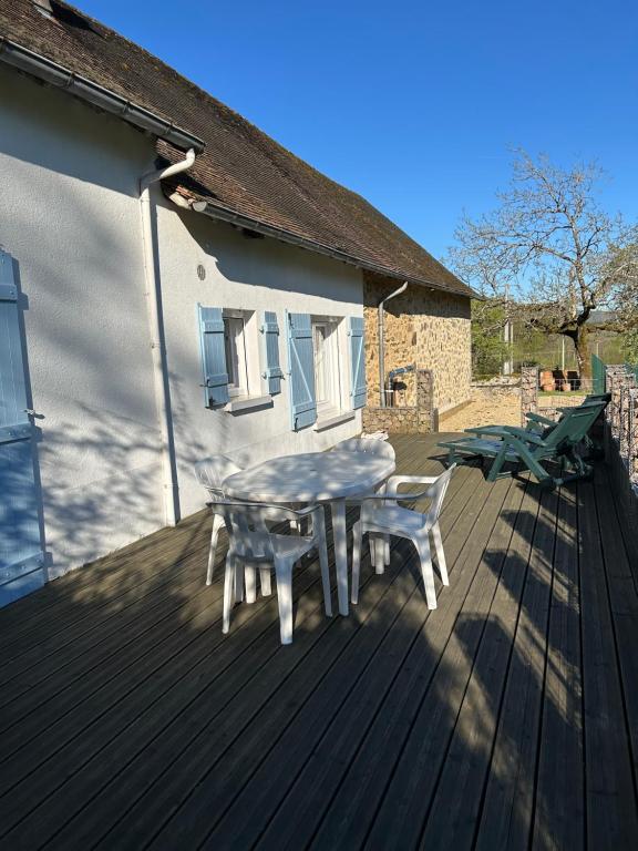 a table and chairs on a wooden deck at Gîte de Lasdoumingeas in Ladignac-le-Long