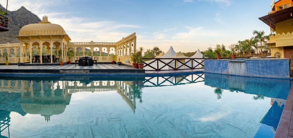a pool of water in front of a building at BADIGARH RESORT - Udaipur in Thūr