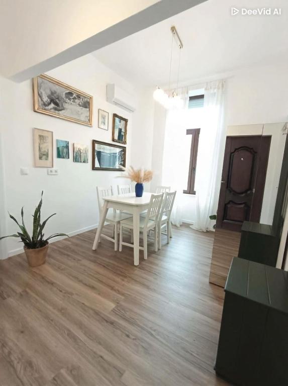 a dining room with a white table and chairs at Zion Central Apartment in Satu Mare