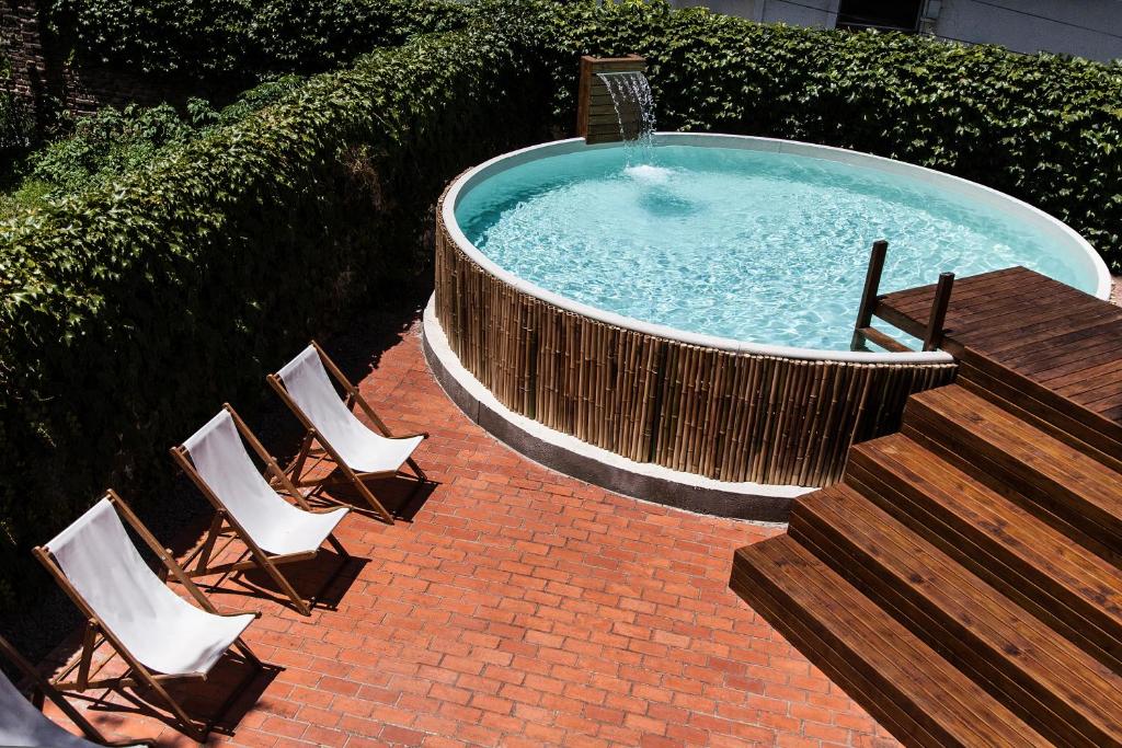 a hot tub with chairs and a table and stairs at Hotel Alto San Isidro in San Isidro