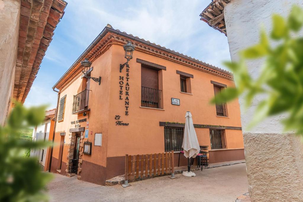 a building with an umbrella in front of it at Hotel El Horno in La Puebla de Valverde