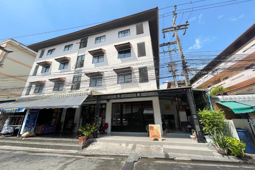 a large white building on the corner of a street at Dad N Mom's House By Thongnak Apartment in Pattaya