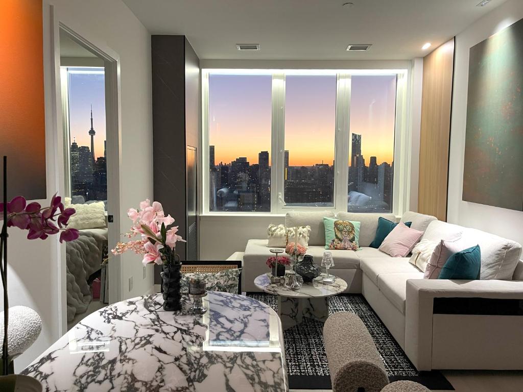 a living room with a white couch and a large window at Luxurious Panoramic Skyline Penthouse 2Bedrooms Suites CN Toronto Downtown in Toronto