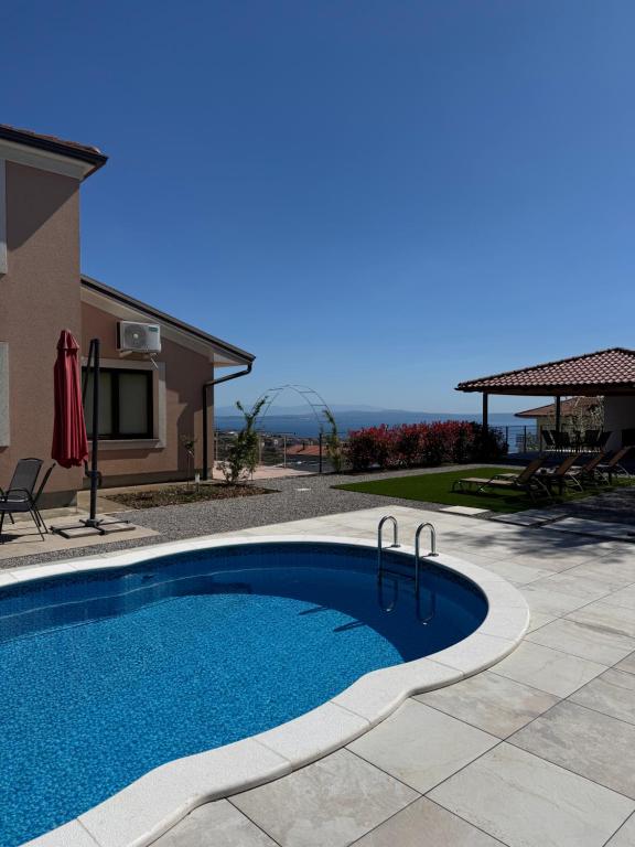 a swimming pool in a yard next to a house at Villa Petra in Kastav