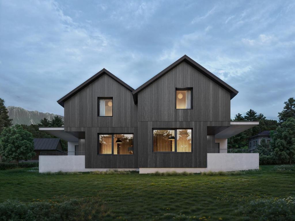 a black house on a grassy field at NOOK - Nature Hideaway in Bad Aussee