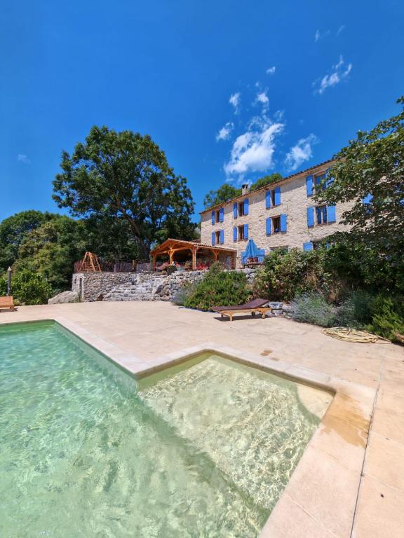 a swimming pool in front of a building at Les Sources chambres dhotes in Bargème