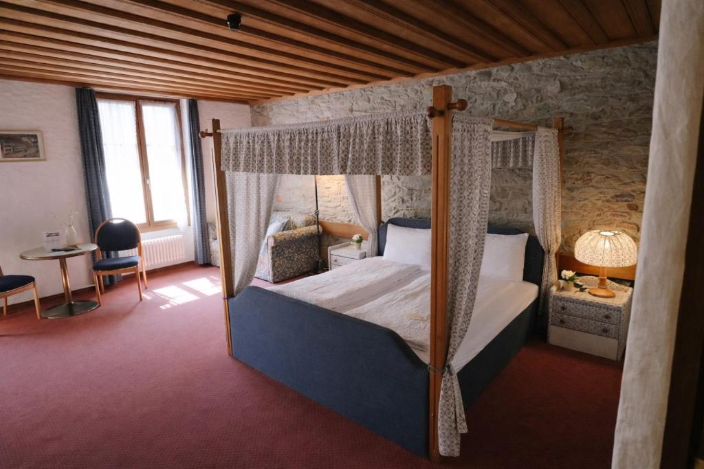 a bedroom with a four poster bed with a canopy at Hotel guter Hirte in Huttwil