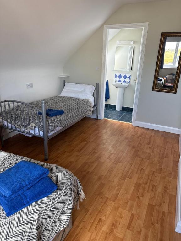 a bedroom with two bunk beds and a wooden floor at Sailing's Island Rooms in Inisheer