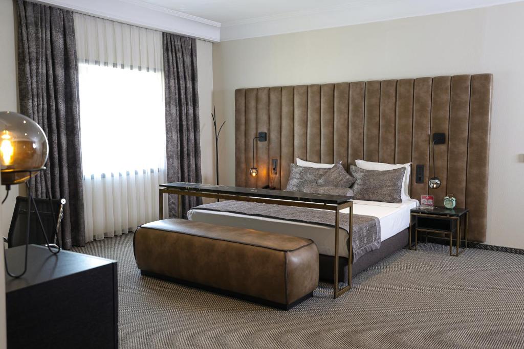 a bedroom with a large bed and a couch at Hotel Rubis in Ferizaj