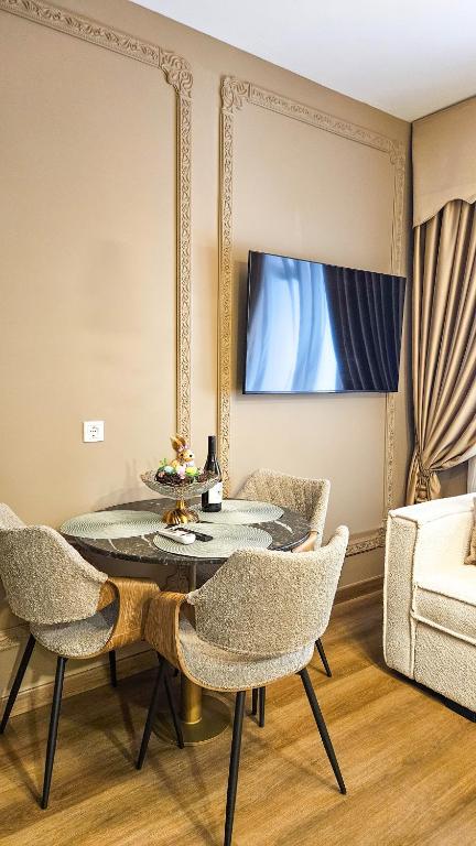 a living room with a table and chairs and a mirror at Maison de Luxe in Chalkida