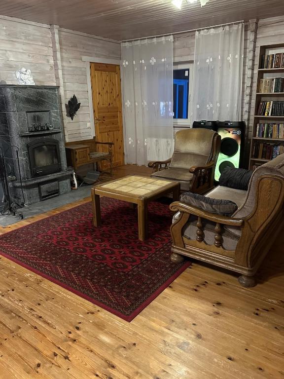 a living room filled with furniture and a fireplace at Pihlamäe holiday house in Aruvalla