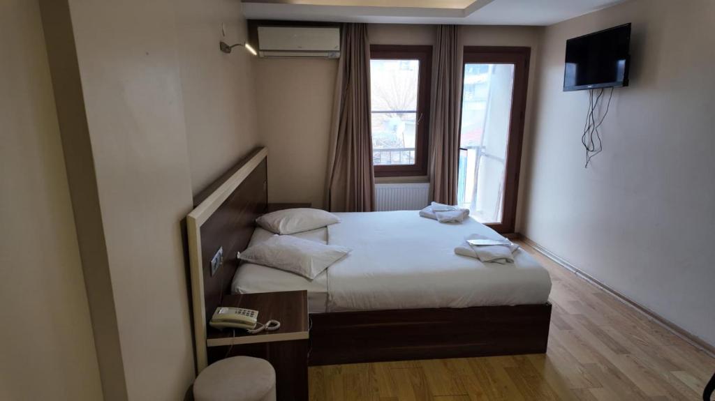 a small bedroom with a bed and a window at Merkez Otel in İzmir